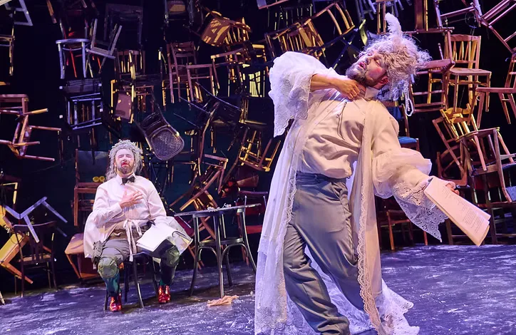 Empty City performance - two dancers on stage with many hanging scattered chairs